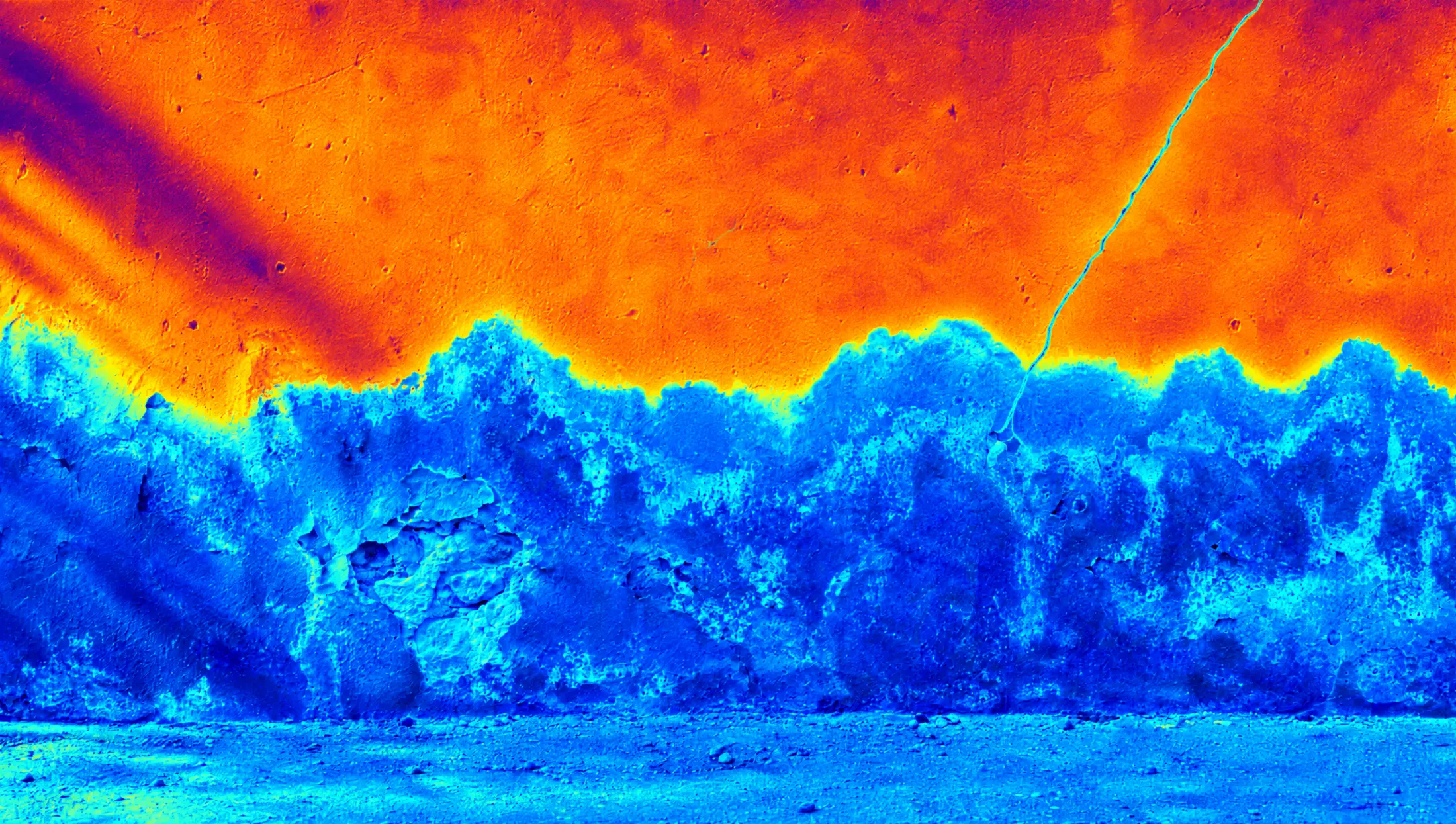 Mur vu en thermographie : la base saturée d'eau apparaît en bleu.